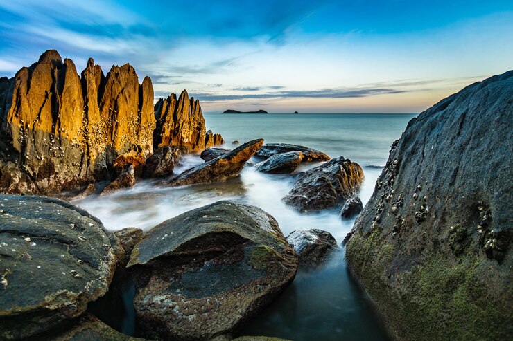 Photo formations rocheuses dans la mer contre le ciel au coucher du soleil