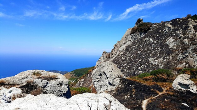 Photo formations rocheuses par la mer contre le ciel bleu