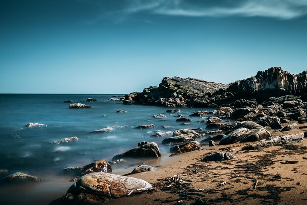 Photo formations rocheuses sur le rivage contre un ciel bleu clair