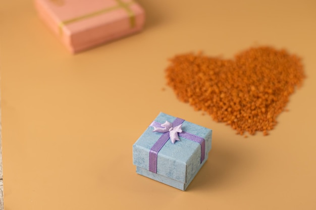 Photo forme de coeur avec des boîtes de cadeaux sur fond orange