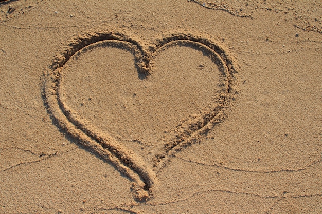 Forme de coeur dessiné sur le sable de la plage