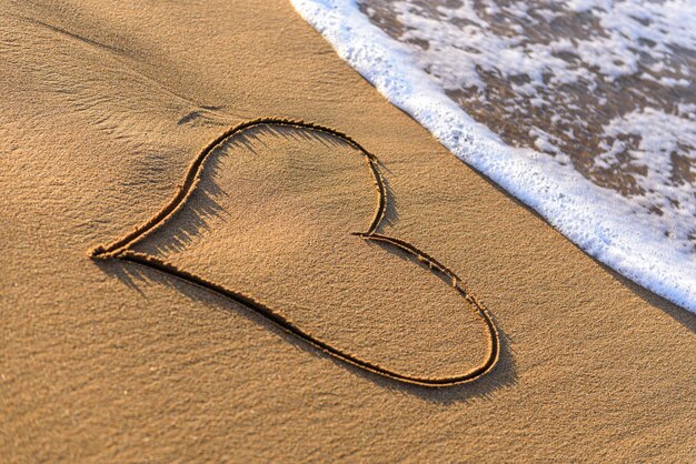 Forme de coeur dessinée dans le sable sur une plage