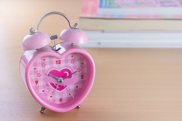Forme de coeur doux rose d'horloge sur la décoration de fond en bois pour l'amour et le concept de la Saint-Valentin