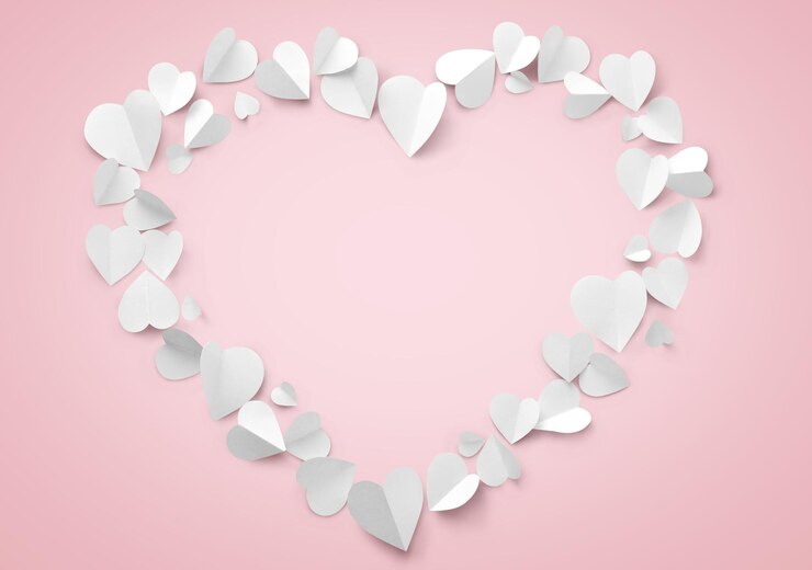 Photo forme de cœur faite avec des papiers sur fond rose