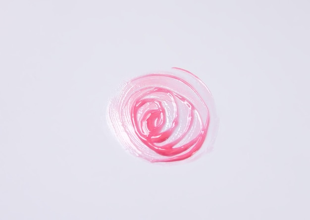 Forme dessinée à la main. Échantillon de brillant à lèvres rose sur fond blanc.