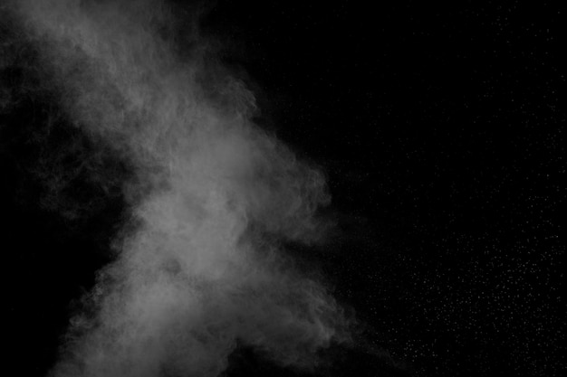 Formes bizarres de nuage d&#39;explosion de poudre blanche sur fond noir. Éclaboussures de particules de poussière blanche.