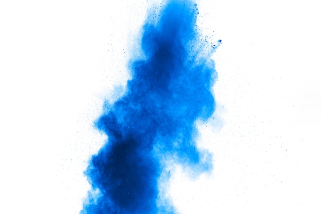 Photo des formes bizarres de poudre bleue explosent en nuage sur blanc.