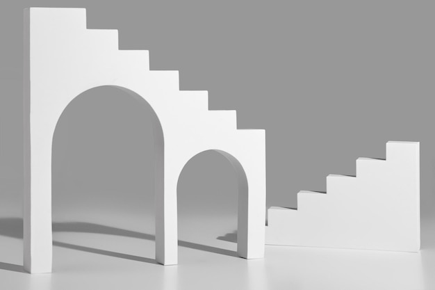 Formes géométriques simples avec arches et marches sur fond gris pour la présentation du produit. Maquette de vitrine abstraite. Image monochrome