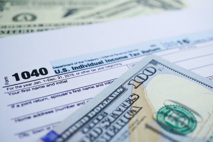 Photo formulaire de déclaration de revenus 1040 et billet en dollars: us individual income.