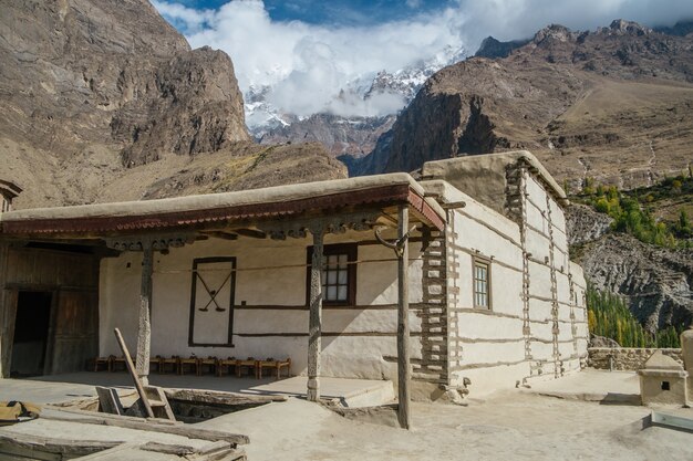 Fort Baltit dans la vallée de Hunza avec nuages et chaîne de montagnes.