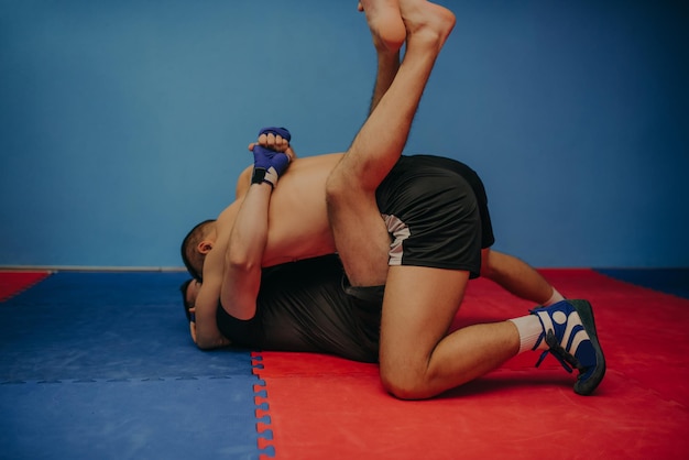 Fort combattant MMA tenant son rival au sol et lui lançant des coups de poing lors d'un entraînement Avec beaucoup d'espace de copie