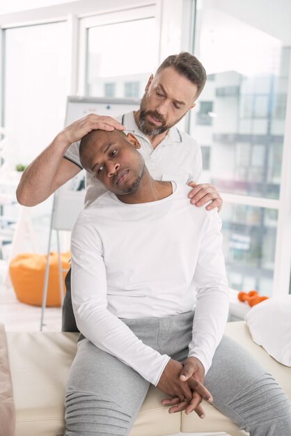 Photo forte douleur. homme triste grave visitant un médecin tout en ayant des douleurs à l'épaule