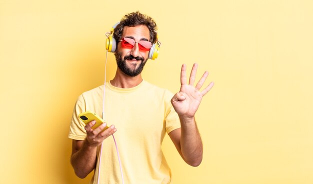 Fou expressif souriant et semblant amical, montrant le numéro quatre avec des écouteurs