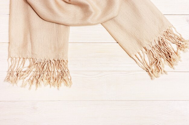 Foulard femme beige mince sur table en bois avec espace de copie