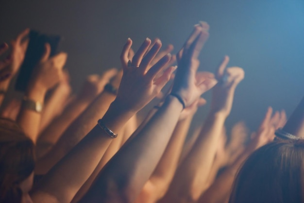 La foule des mains et la célébration ou les amis au festival de musique la collaboration et la liberté à la boîte de nuit les gens de près et le week-end à la fête ou à l'événement social concert et communauté ou ensemble au spectacle