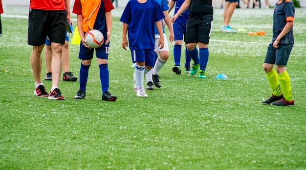 Foule de nombreux enfants jouant au football sur le terrain en herbe des stades