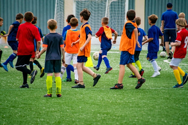 Foule de nombreux enfants jouant au football sur le terrain en herbe des stades