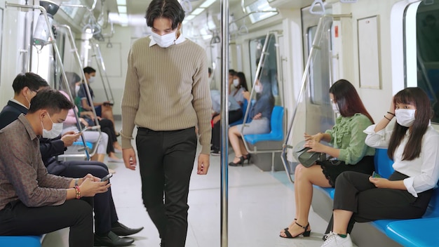 Foule de personnes portant un masque facial lors d'un voyage en métro public bondé. Maladie du coronavirus ou épidémie de pandémie de COVID 19 et problème de mode de vie urbain dans le concept d'heure de pointe.