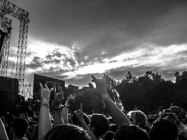 Photo une foule qui profite d'un festival de musique contre un ciel nuageux