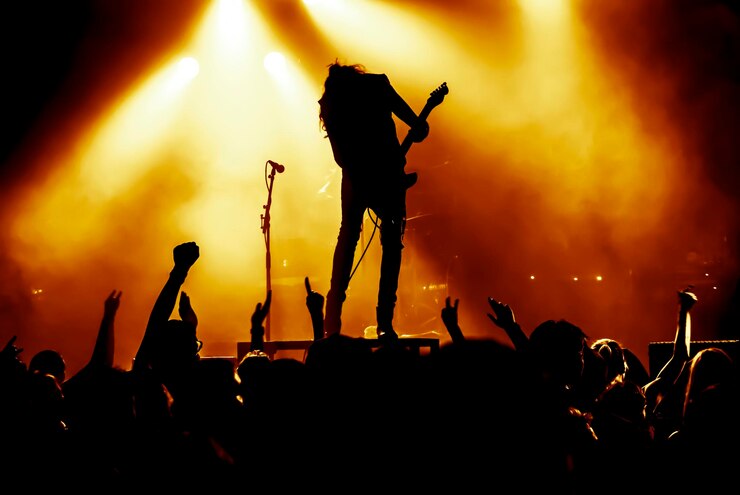 Photo une foule en silhouette apprécie le guitariste jouant de la guitare sur scène pendant un concert