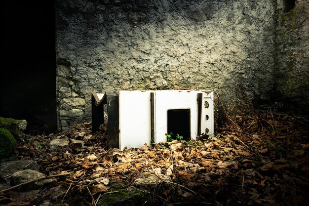 Four vieux et rouillé dans le sol de la maison abandonnée de feuilles sèches