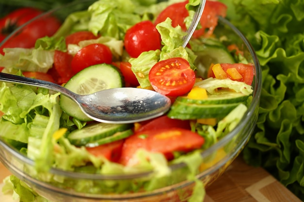 Fourchette en argent en assiette mélange salade de légumes frais
