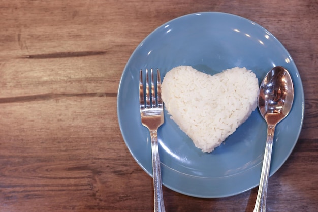 Photo une fourchette sur une assiette de riz nature biologique sur un plat en céramique bleue sur une table en bois