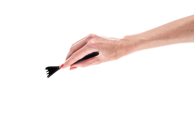 Fourchette en plastique noir dans la main féminine isolé sur fond blanc