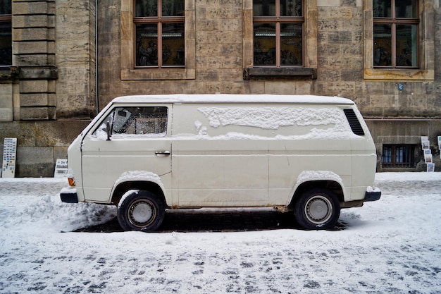 Photo une fourgonnette couverte de neige sur le trottoir contre un bâtiment