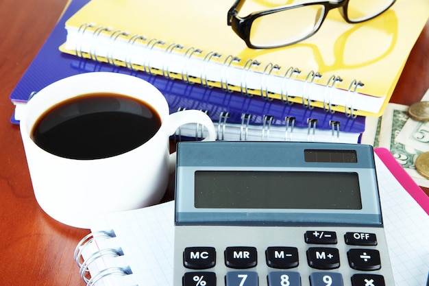 Photo fournitures de bureau avec de l'argent et une tasse de café en gros plan