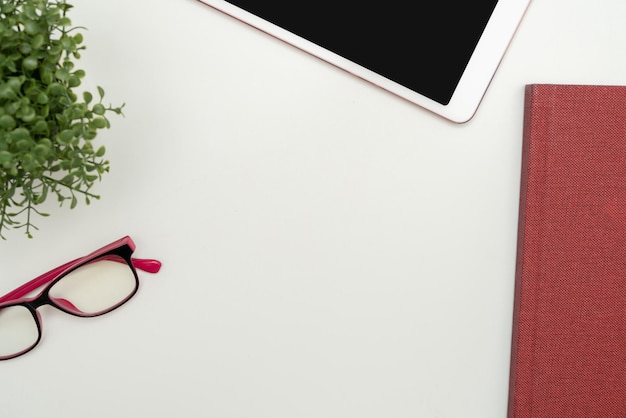 Fournitures de bureau sur le bureau avec clavier, verres et tasse à café pour travailler à distance Utilitaires scolaires assortis pour étudier avec boisson chaude et lunettes