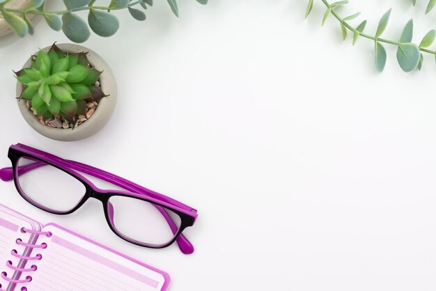 Fournitures de bureau sur le bureau avec clavier, verres et tasse à café pour travailler à distance Utilitaires scolaires assortis pour étudier avec boisson chaude et lunettes