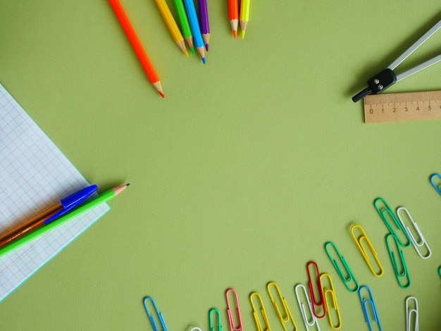 Fournitures de bureau sur fond vert avec place pour le texte