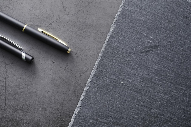 Fournitures de bureau sur la table. Un stylo. Stylo d'affaires au bureau sur une surface en pierre.