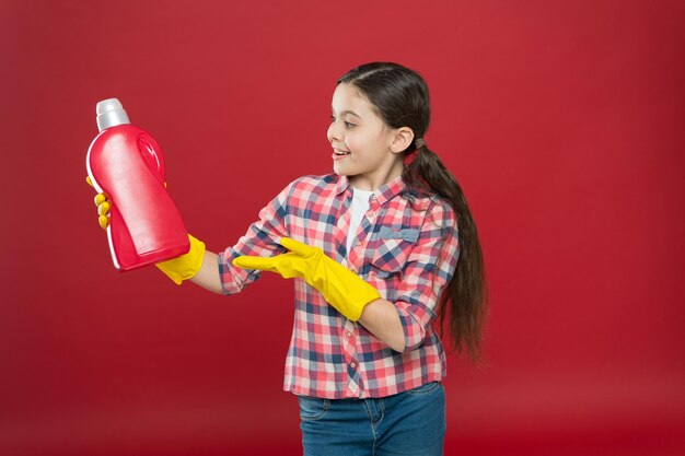 Les fournitures de nettoyage. Gels désinfectants adaptés à toute la famille. Fille dans des gants en caoutchouc pour le nettoyage tenir une bouteille en plastique liquide chimique. Aide à nettoyer. Utiliser le produit pour le nettoyage. Concept d'entretien ménager.