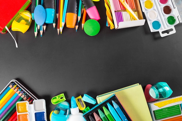 Fournitures scolaires bordure inférieure sur un tableau noir