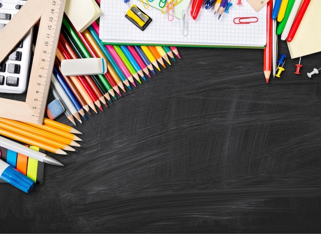 Fournitures scolaires colorées sur fond de bois