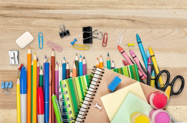 Fournitures scolaires colorées sur fond de bois