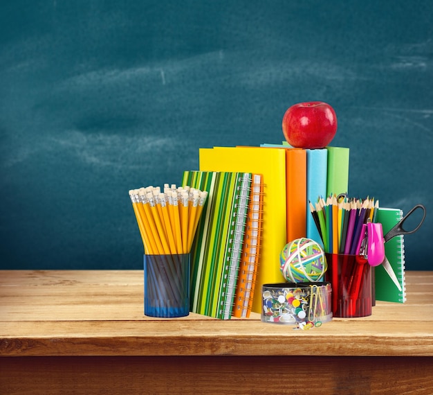 Fournitures scolaires colorées sur fond en bois