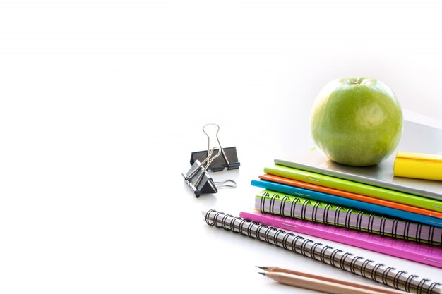 Fournitures scolaires colorées, livre, pomme sur blanc. Fermer. Retour à l&#39;école.