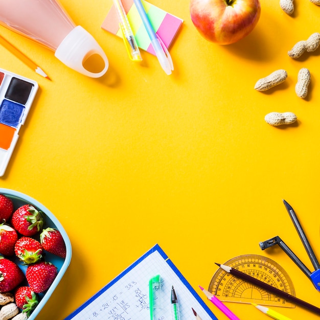 Fournitures Scolaires De L'enfant Et Déjeuner Dans Des Boîtes En Plastique Sur Fond Jaune