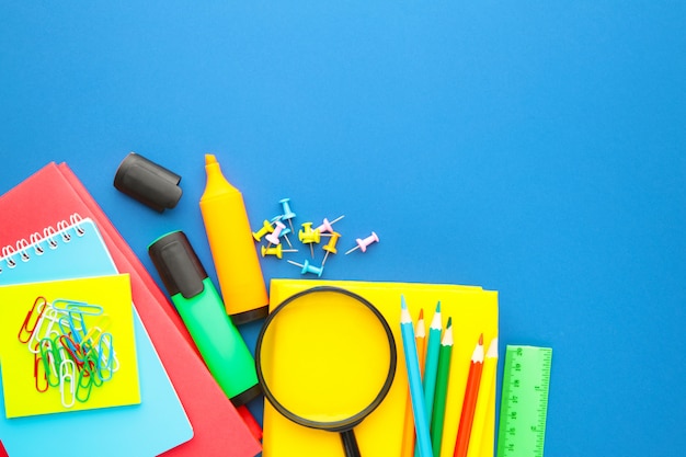 Fournitures scolaires sur fond bleu. Retour à l'école. Mise à plat.