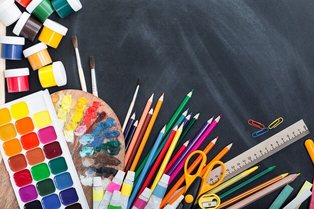 Fournitures scolaires sur le fond du tableau des enseignants