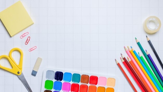 Fournitures scolaires sur fond de papier à carreaux blancs Retour à l'école Début de la nouvelle année scolaire