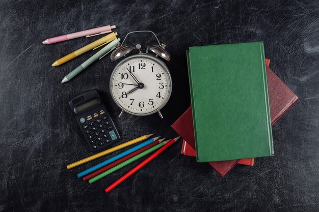 Fournitures scolaires sur un fond de tableau. Retour à l'école. Vue de dessus.