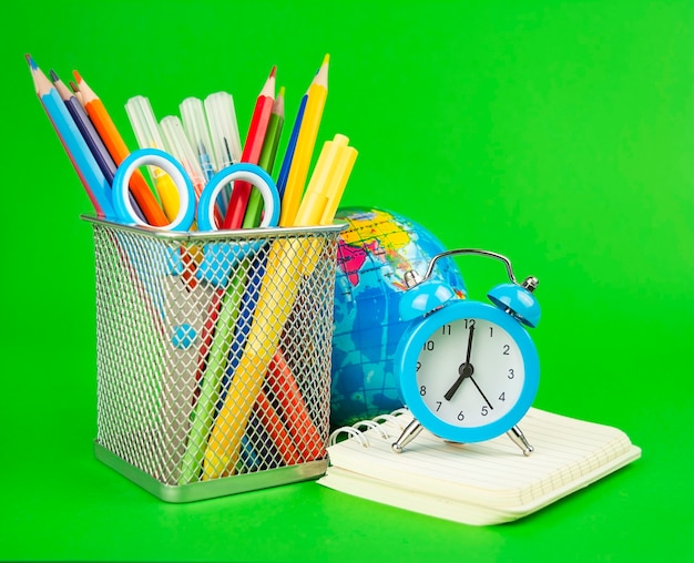 Fournitures scolaires sur fond vert. Notion d'éducation. Retour à l'école. Bannière. Espace de copie.