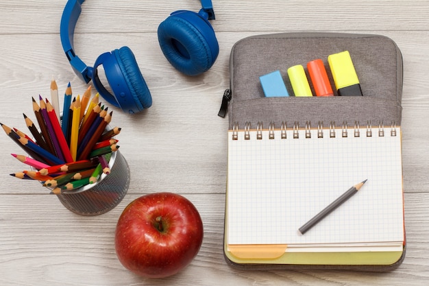 fournitures scolaires stand pomme pour crayons avec crayons de couleur casque retour au concept de l'école