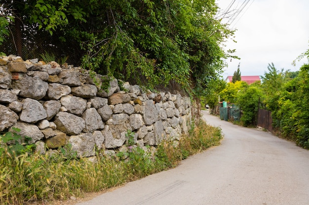 Fragment de l'ancien mur de pierre de la clôture de la maison. Vue depuis la rue.