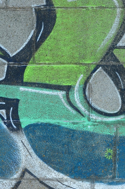 Fragment de dessins de graffitis Le vieux mur décoré de taches de peinture dans le style de la culture de l'art de la rue Texture de fond colorée dans les tons verts