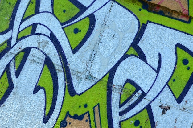 Fragment de dessins de graffitis Le vieux mur décoré de taches de peinture dans le style de la culture de l'art de rue Texture de fond colorée en tons verts